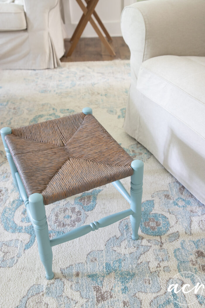 blue and brown colored footstool on cream and blue rug