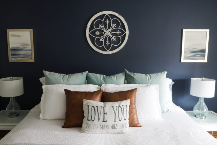 bed with pillows and matching abstract beach art on the walls