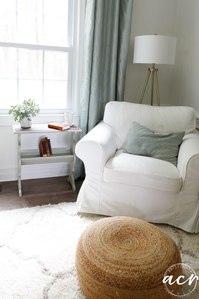 white chair, ottoman with green table beside