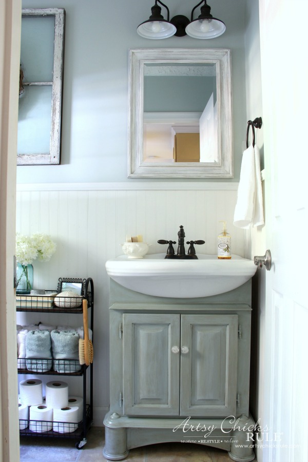 blue bath cabinet, white mirror on blue wall