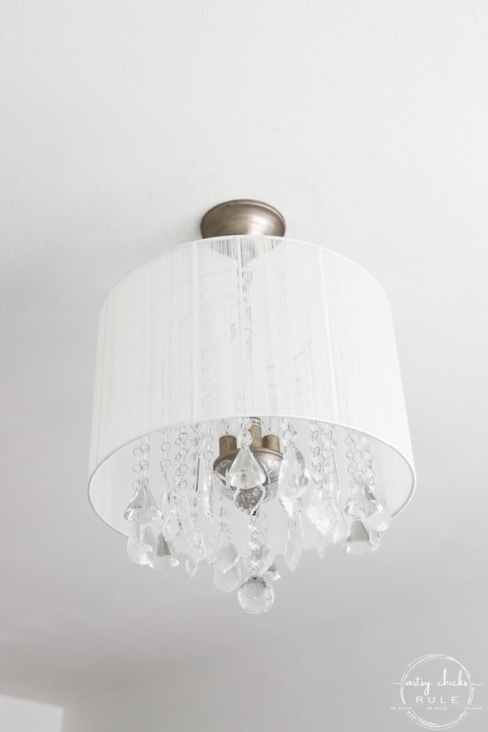 crystal chandelier and white drum shade