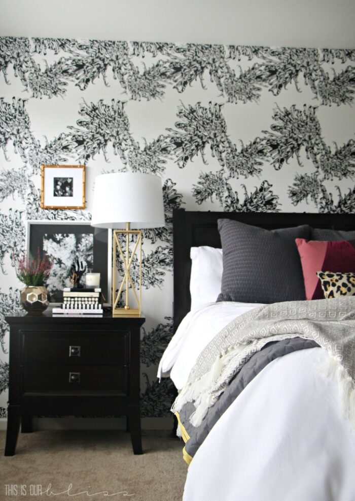 black and white wallpaper behind bed