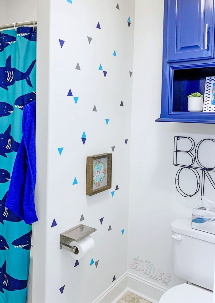 white wall with blue and gray triangle cutouts attached in bathroom
