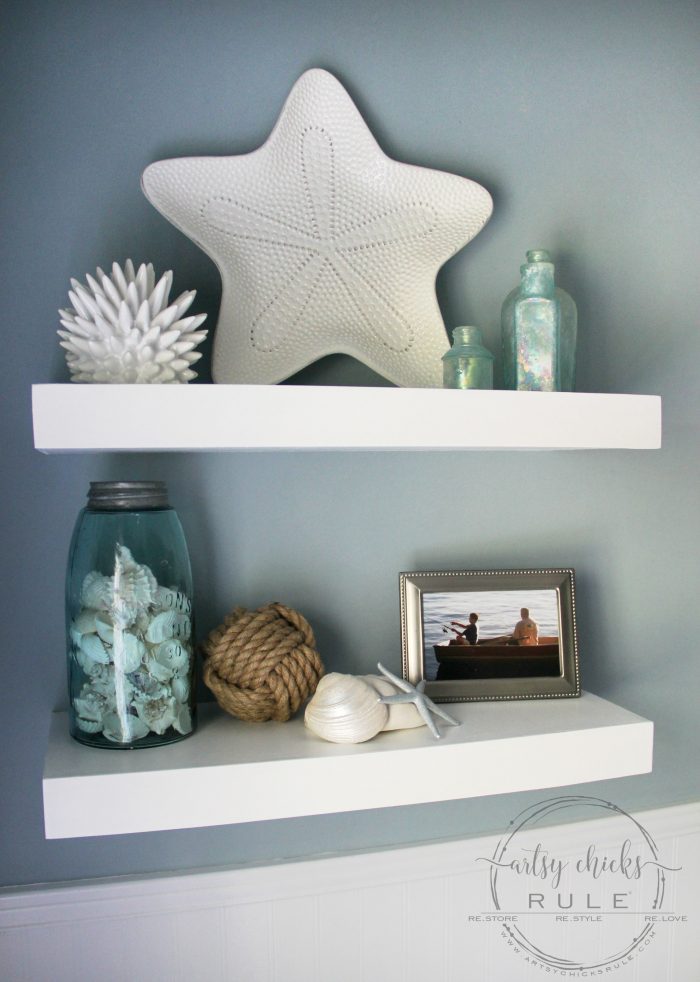 white shelves on wall with coastal style decor and blue wall
