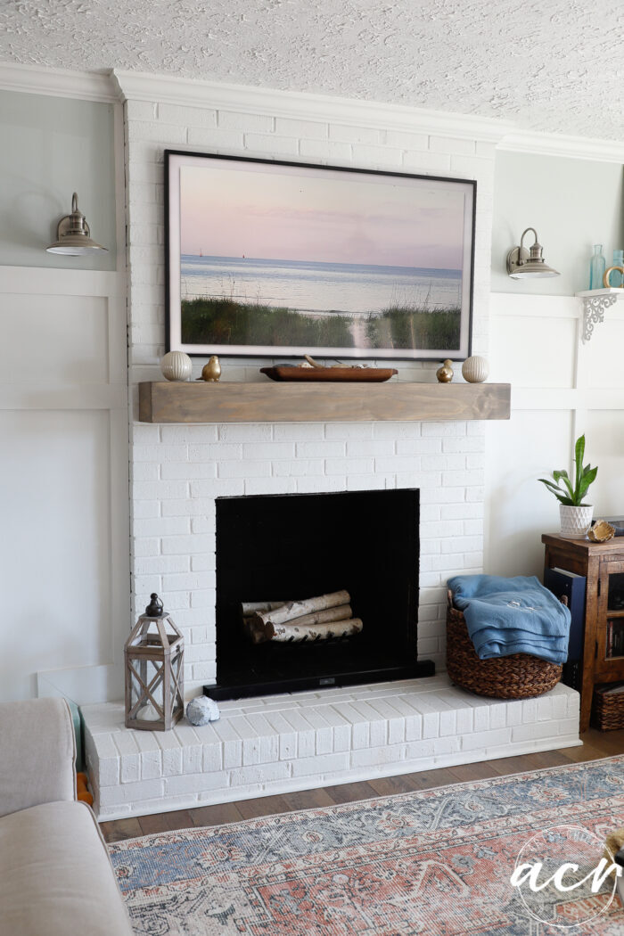 wood mantel with artwork on TV