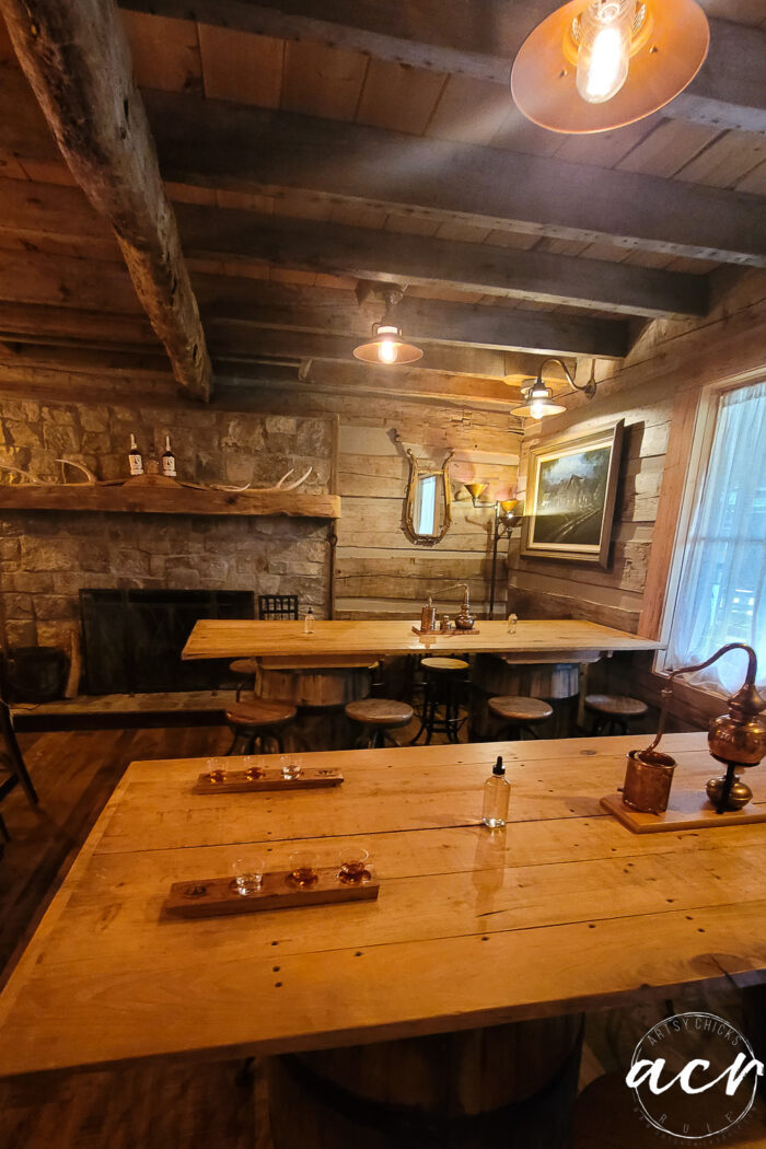 tables, ceiling and stone fireplace inside tasting room