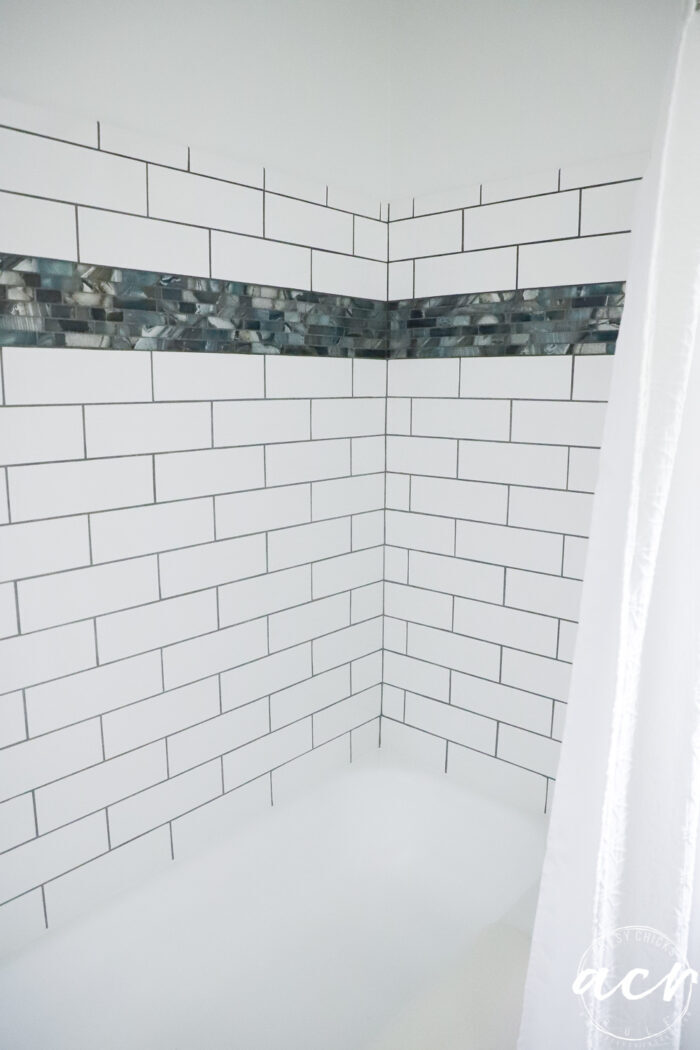 white subway tiled shower with multi blue accent tile