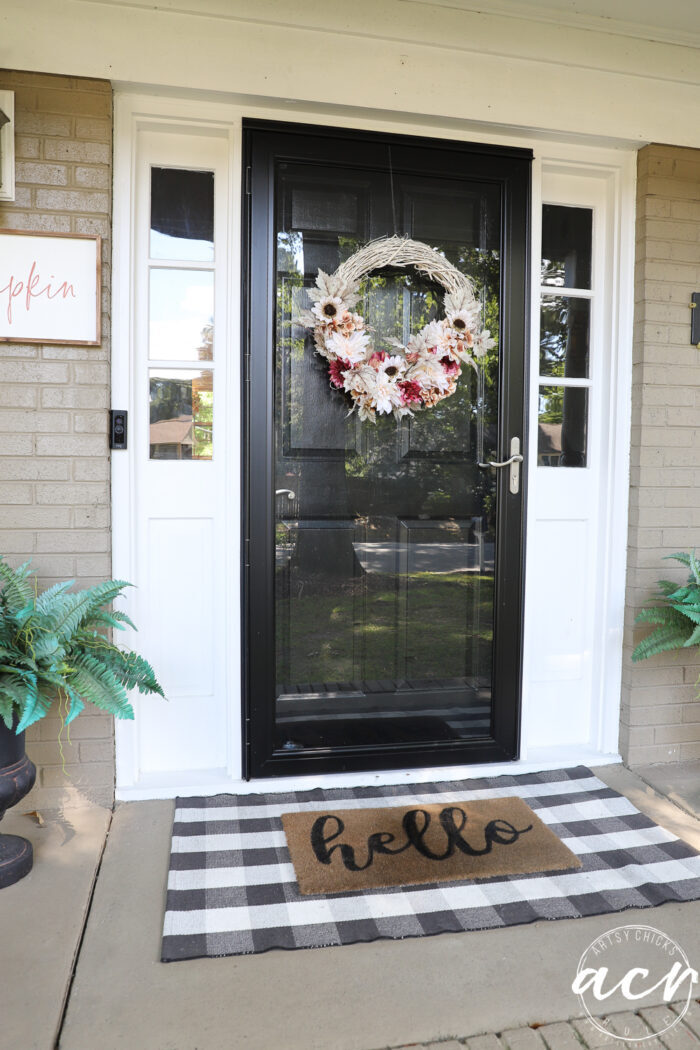 black front door with white sidelights and hello door mat