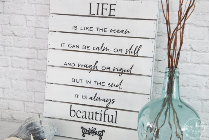 life is like the ocean sign with aqua glass jar and branches with seashells