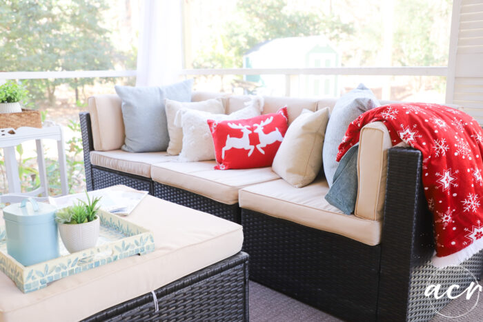 outdoor couch with red blanket and red pillow