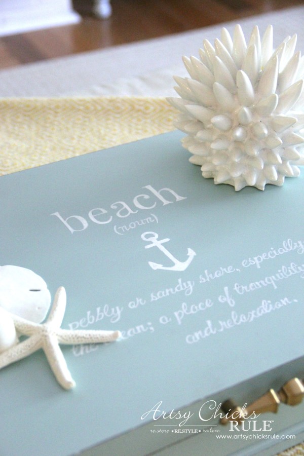 blue box with white writing and seashells