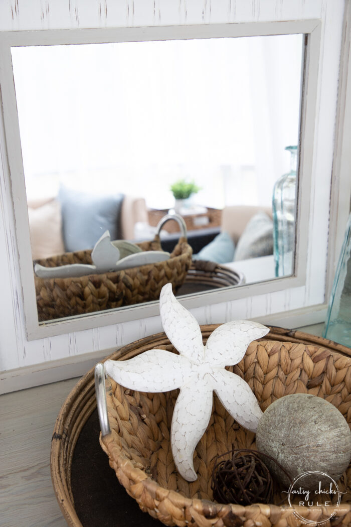 basket tray with basket and white starfish in front of mirror