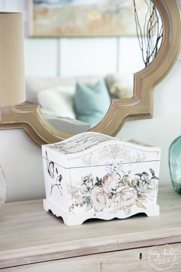 white treasures box with rose floral pattern on front with gold mirror behind