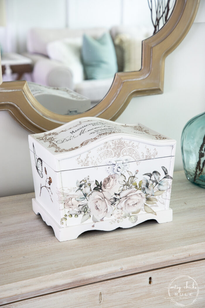 whitewashed dresser with white keepsake box and gold mirror