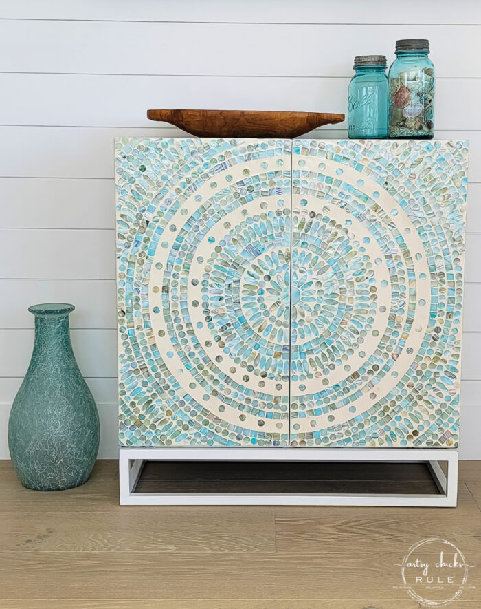 aqua mosaic tile cabinet with blue jars and wood bowl