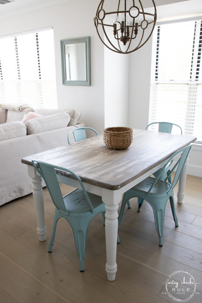 weathered driftwood table with blue metal chairs