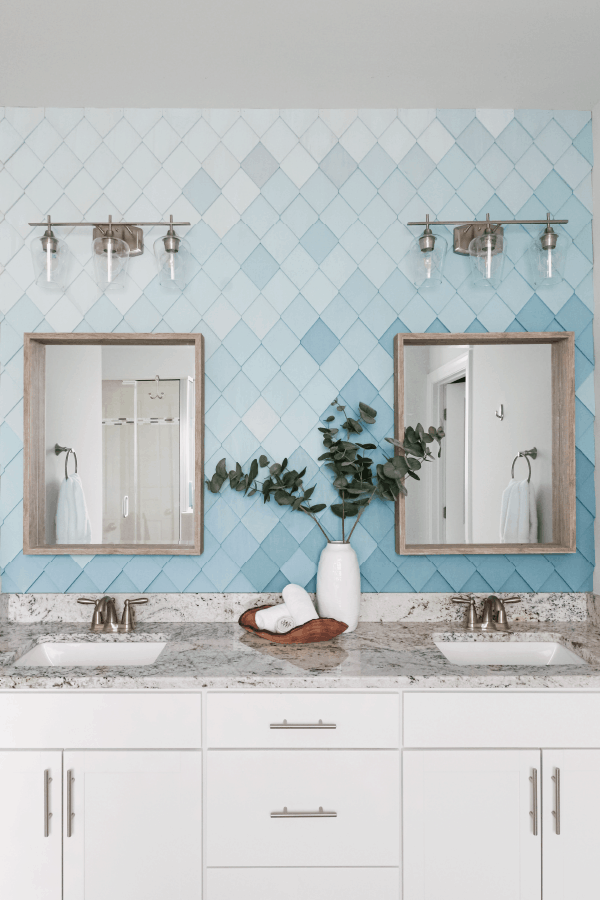 ombre blue wall with diamond shaped wood wall treatment behind 2 mirrors over sinks